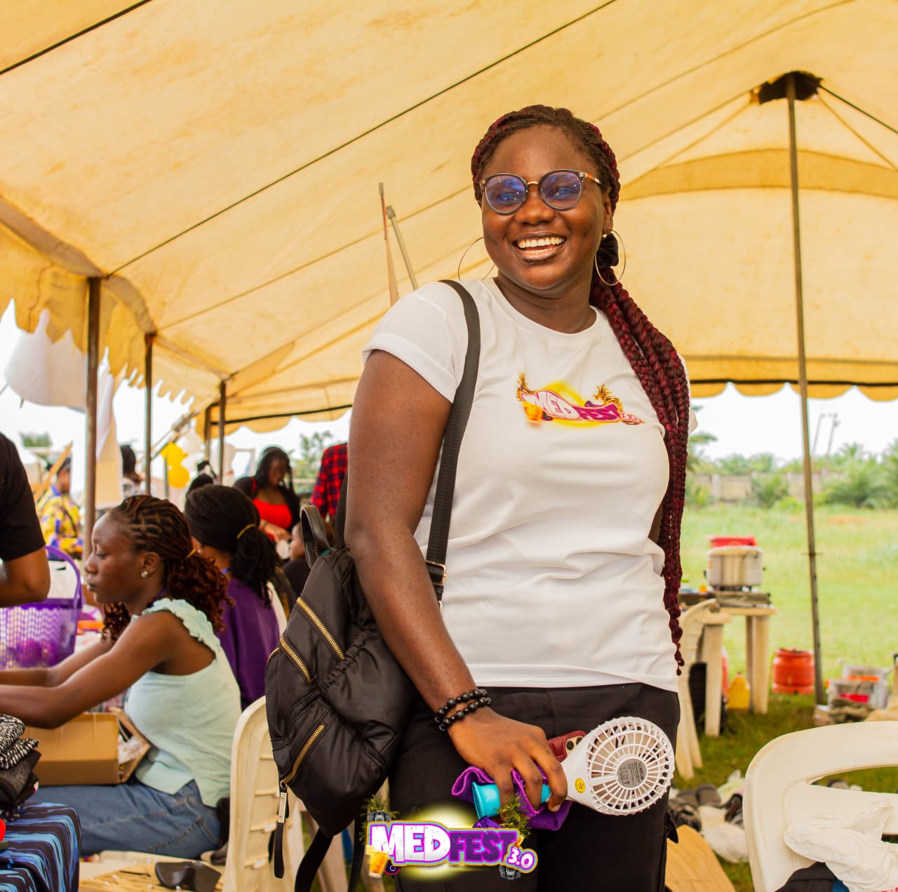A guest smiling in a yellow festival tent